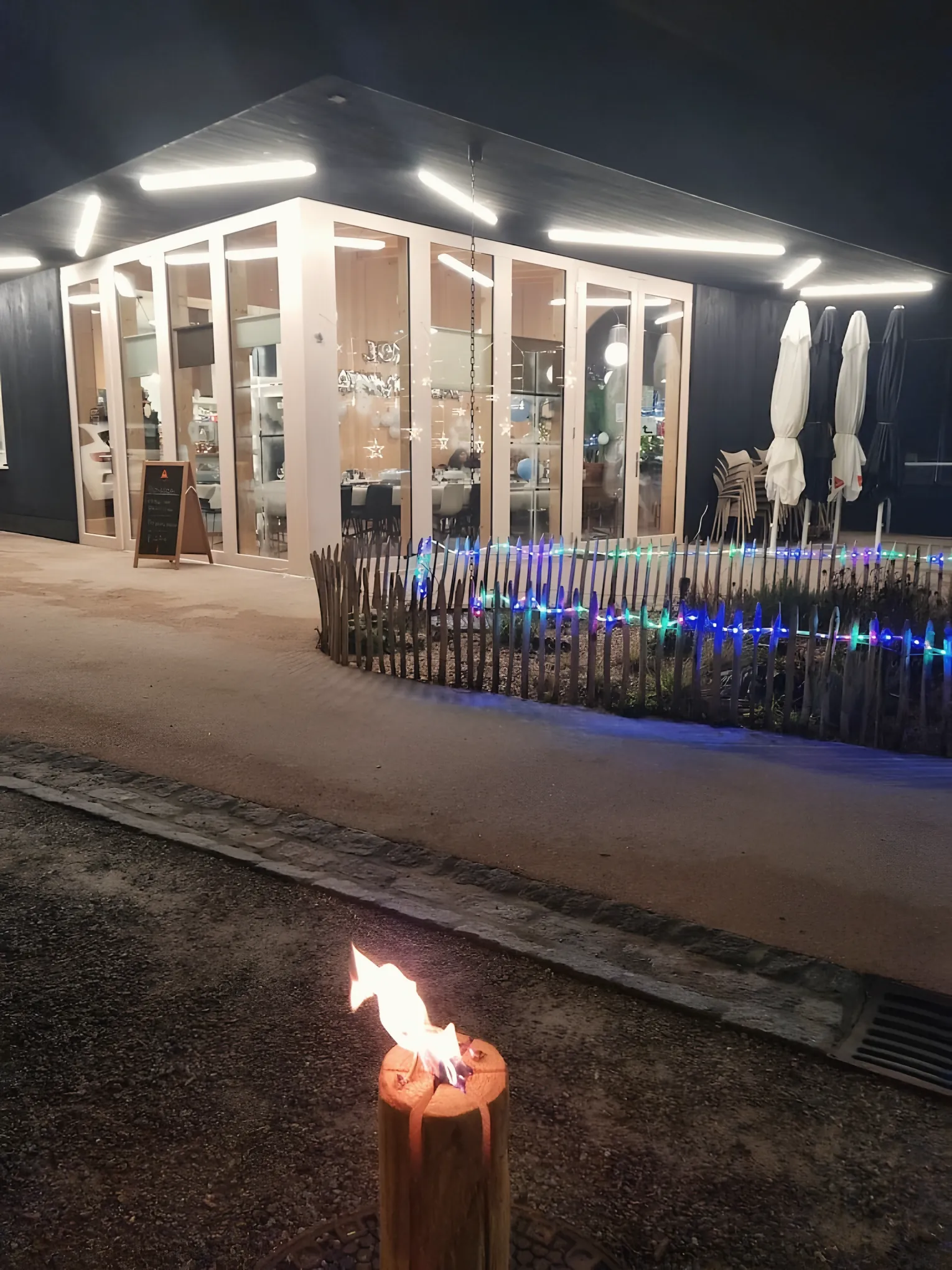 La buvette du Chervi illuminée le soir, avec sa terrasse